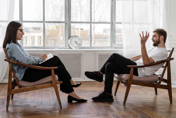 Man and woman sitting across from each other in a behavioural clinic