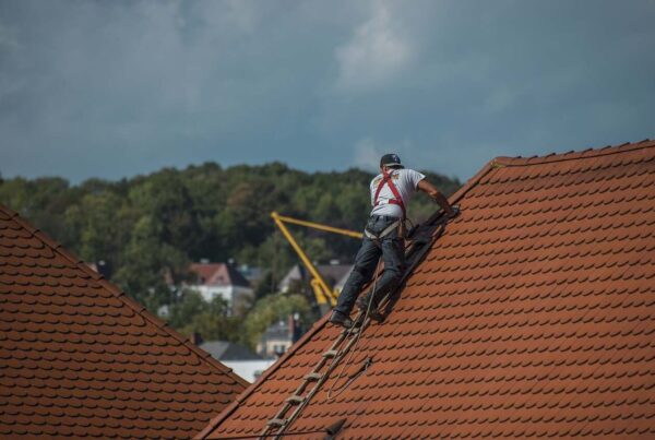 Man on the roof fixing it. with ladder